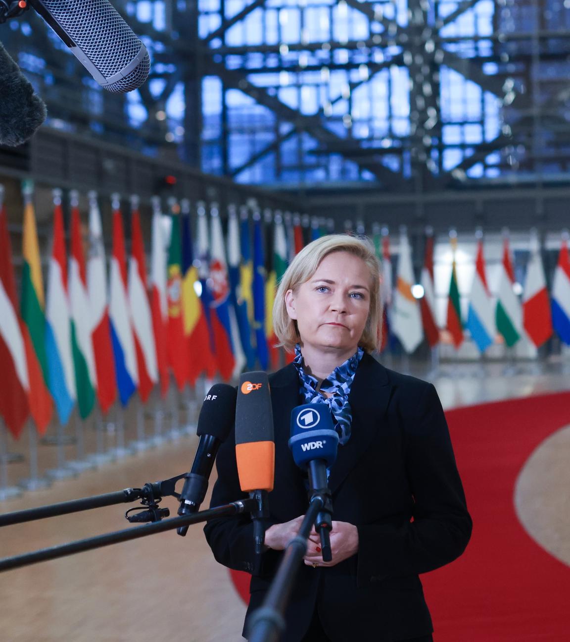 Die finnische Innenministerin Mari Rantanen steht vor europäischen Flaggen.