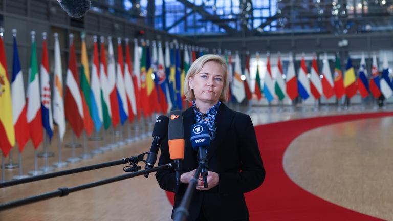 Die finnische Innenministerin Mari Rantanen steht vor europäischen Flaggen.