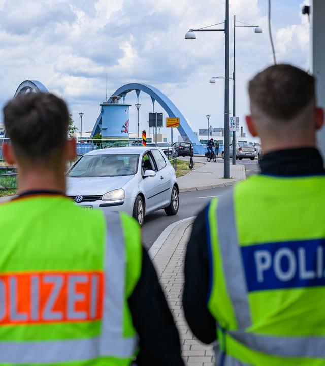11.06.2026, Brandenburg, Frankfurt (Oder): Zwei Beamte der Bundespolizei stehen am deutsch-polnischen Grenzübergang Stadtbrücke bei der Einreise nach Deutschland.