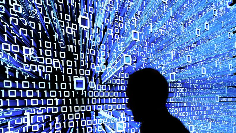 Ein Messebesucher geht an einem Leuchtdisplay auf der CeBIT vorbei. 