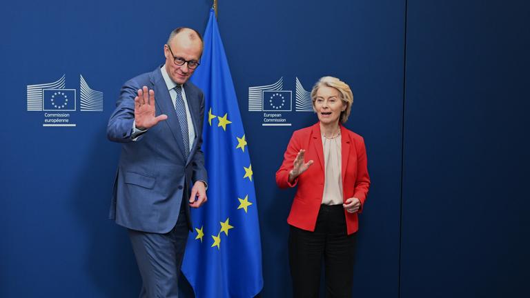 Friedrich Merz und Ursula von der Leyen vor der deutschen und europäischen Flagge
