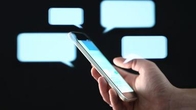 Textnachrichten auf dem Handybildschirm mit abstrakten Hologramm-Sprechblasen.