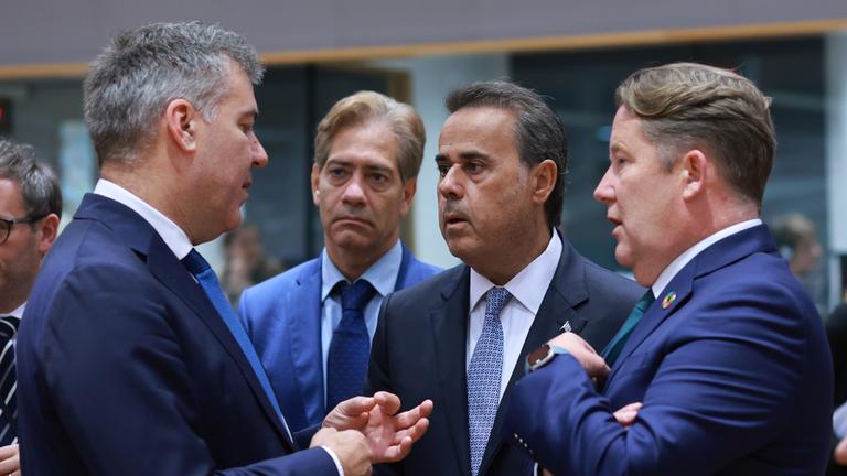 Vier Männer in Anzügen, die im Gespräch sind - darunter der dänische Minister für Klima und Energie, Lars Aagaard (links), und der griechische Minister für Energie und Umwelt, Stavros Papastavrou (zweiter von rechts),im Gespräch.