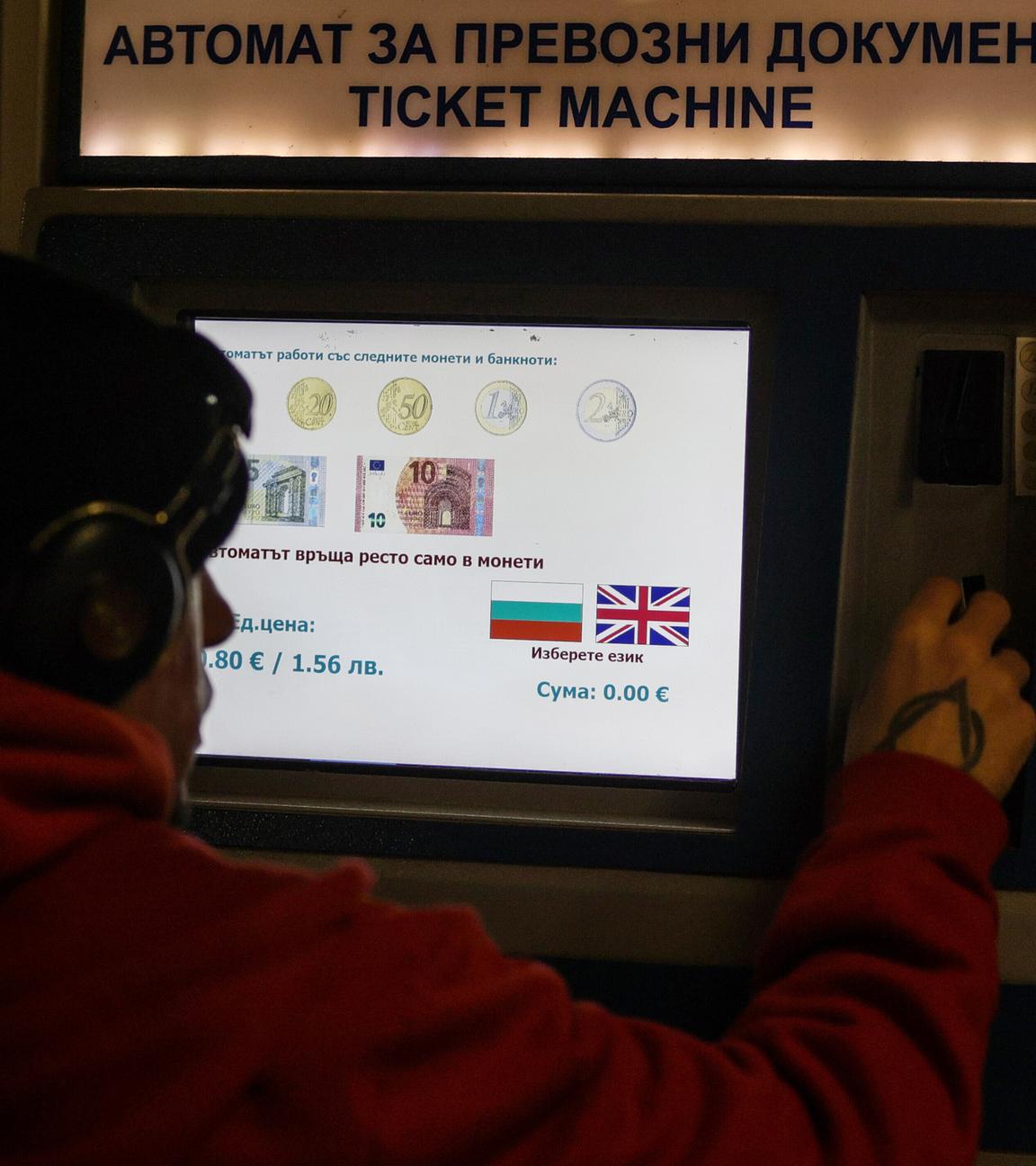Eine Person kauft Fahrkarten an einem Automaten, auf dem angegeben ist, welche Euro-Banknoten und -Münzen akzeptiert werden, da das Land der Euro-Währungsunion beitritt.