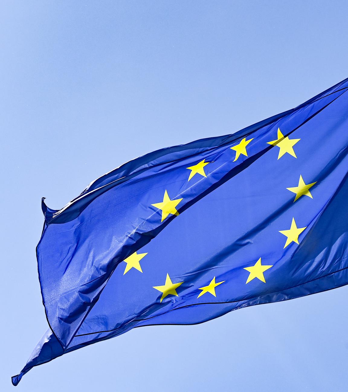 Die Europaflagge weht vor blauem Himmel. 