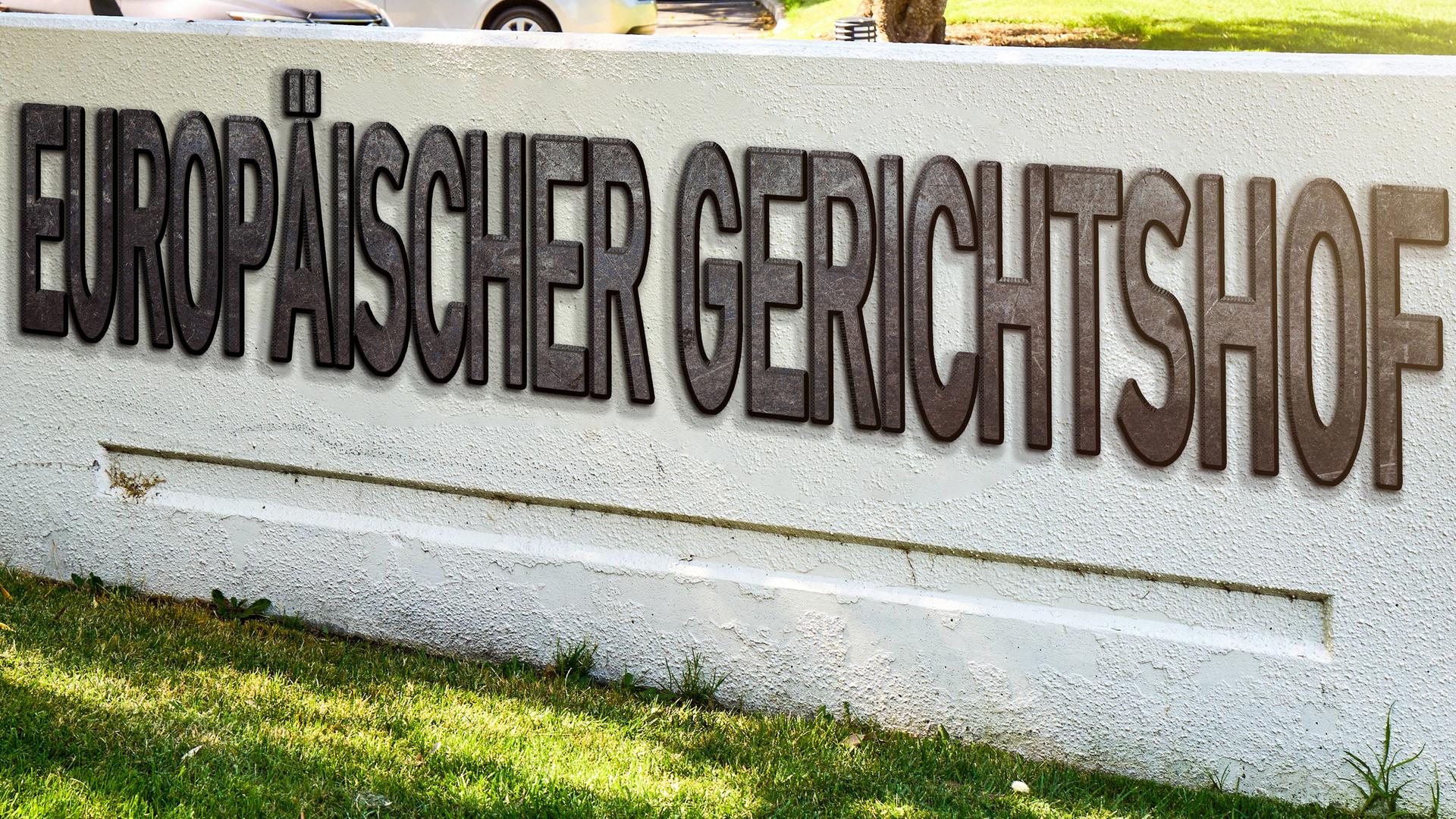 Europäischer Gerichtshof EuGH, steht auf einer Mauer auf Stein. 