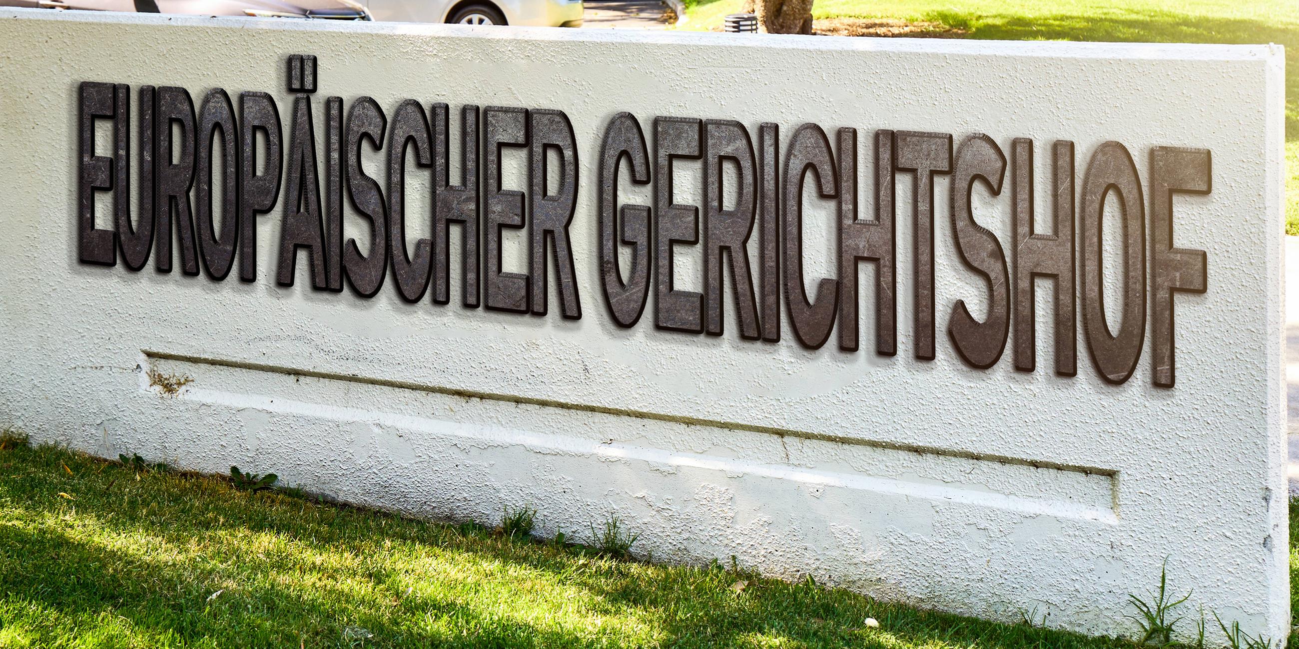 Europäischer Gerichtshof EuGH, steht auf einer Mauer auf Stein. 