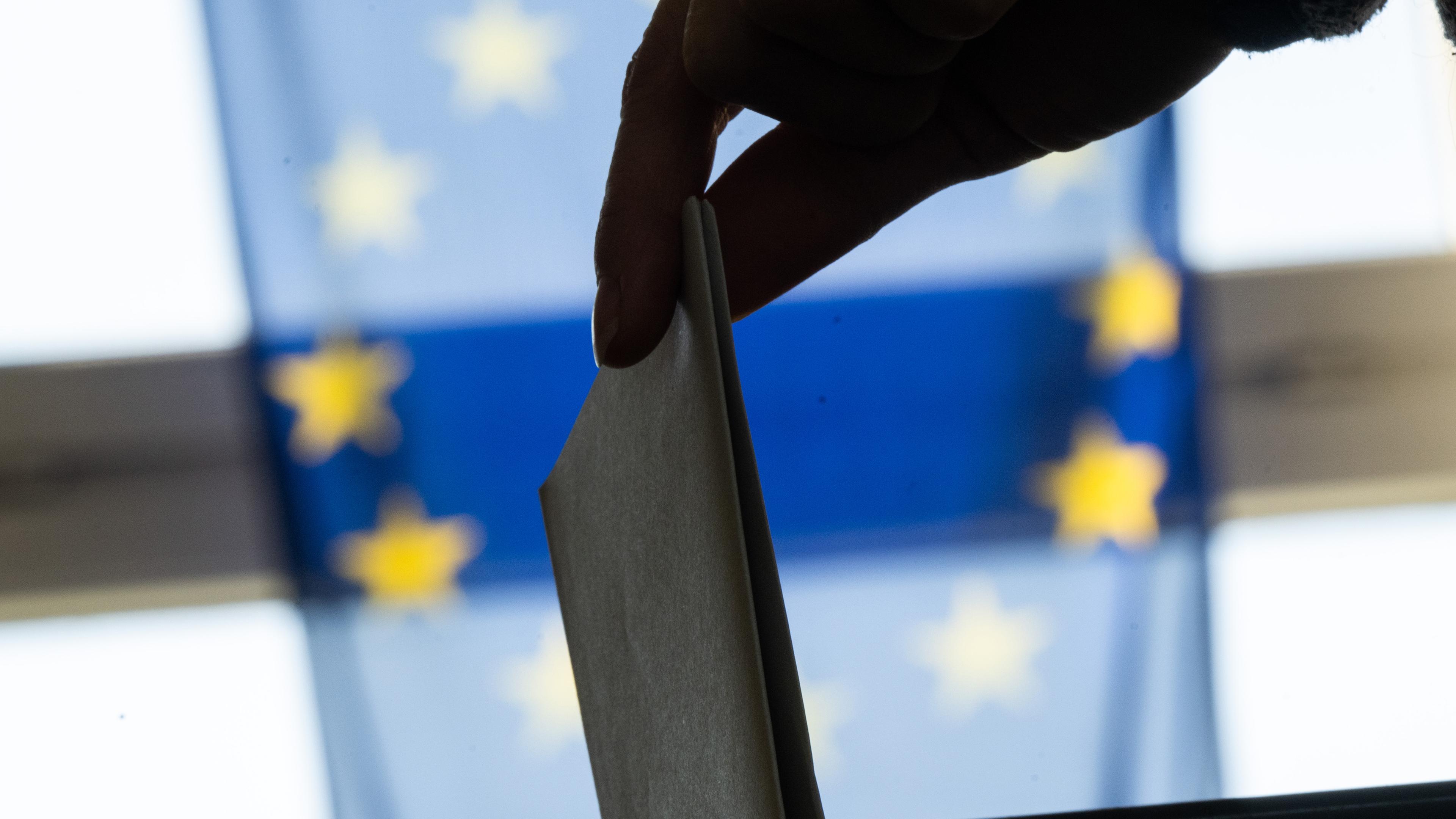 Eine Frau wirft in einem Wahllokal im Bezirk Lichtenberg ihren Wahlzettel für die Europawahl ein.