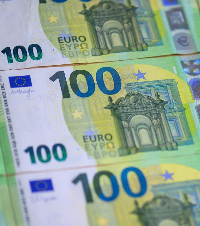 Mehrere 100 Euro Banknoten liegen auf einem Tisch.