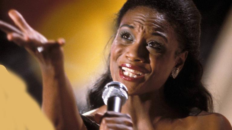 Evelyn Thomas singend, mit einem Mikrofon in der Hand