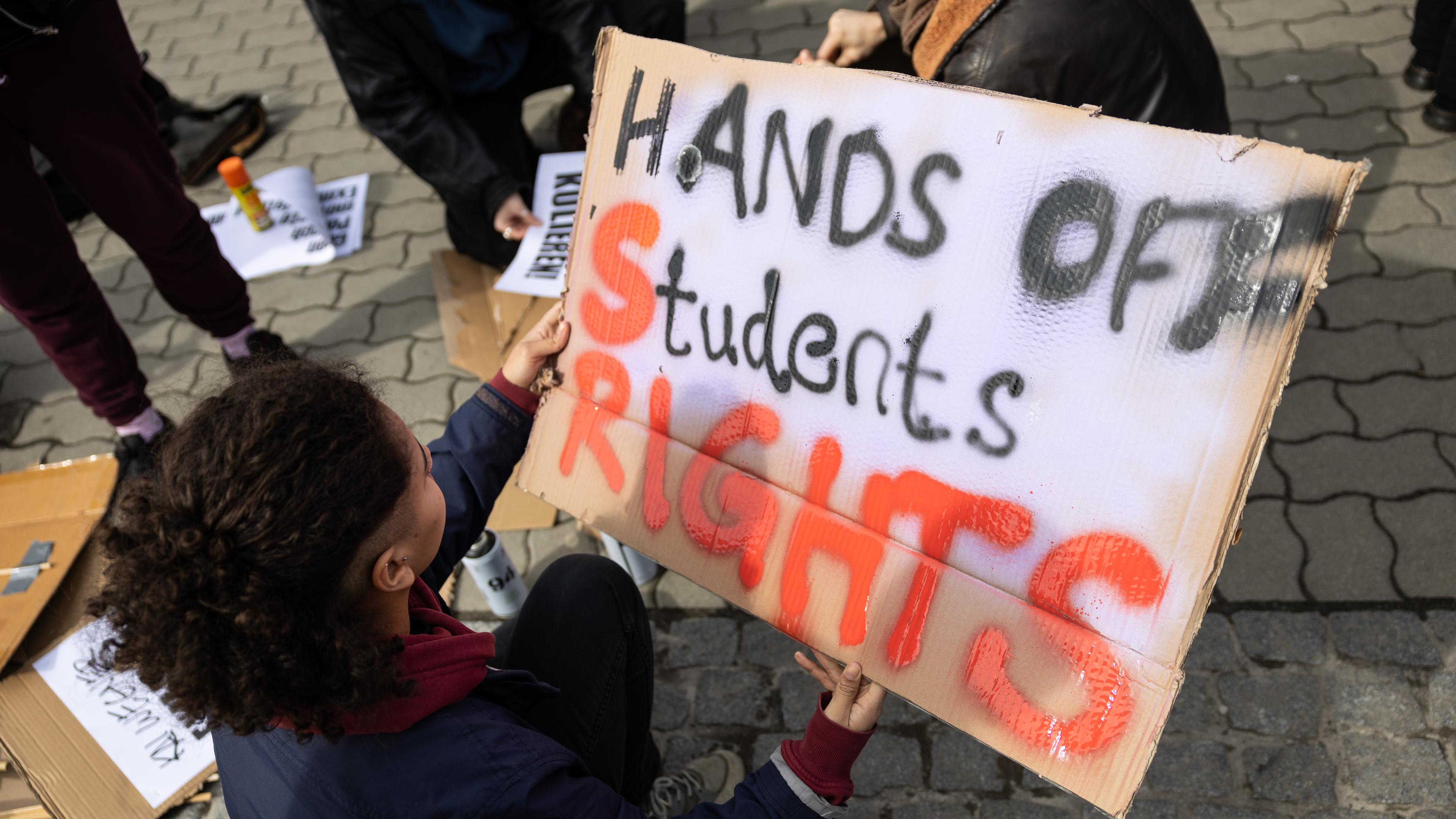 Schild für Protestaktion gegen politisch motivierte Exmatrikulationen