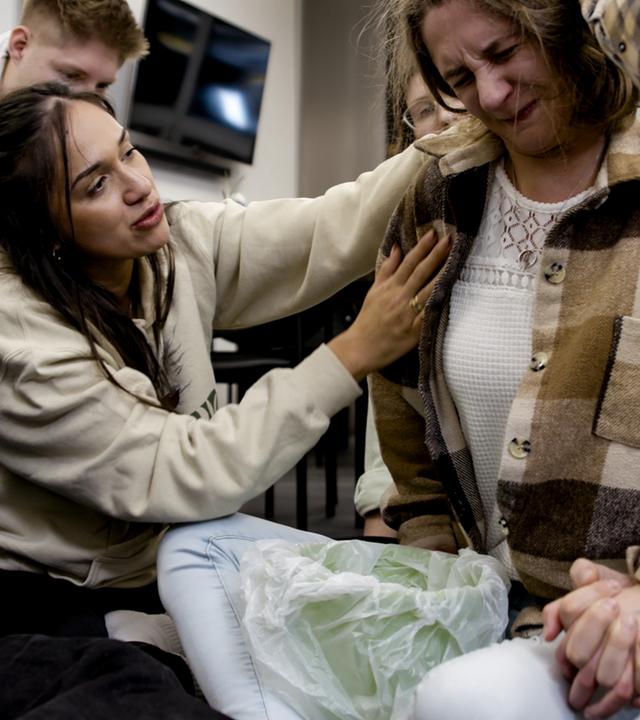 Rose de Jesus legt bei einem Befreiungsdienst die Hand auf die Brust einer Betroffenen.