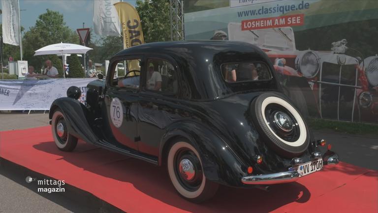 Ein Oldtimer wird auf dem roten Teppich ausgestellt