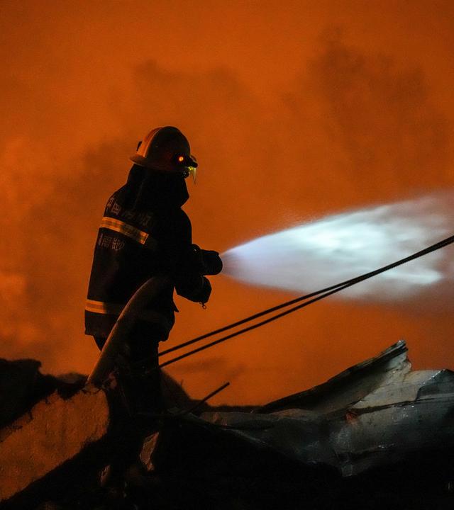 Ein Feuerwehrmann arbeitet vor Ort nach einer Explosion in einer Feuerwerksfabrik in der Stadt Guandu in Liuyang in der zentralchinesischen Provinz Hunan.