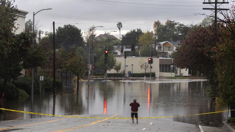 Ein Mann blickt auf eine überflutete Kreuzung im Stadtteil South Pasadena von Los Angeles.