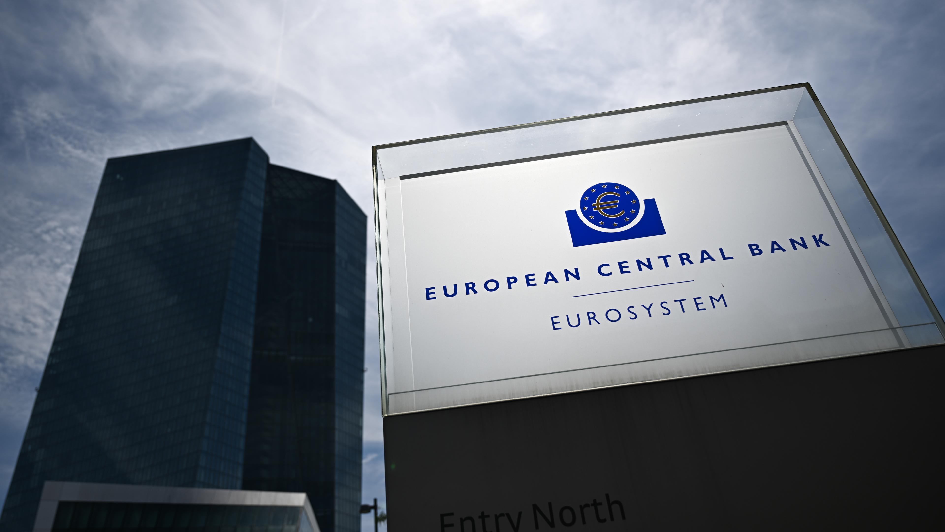 18.07.2024, Hessen, Frankfurt/Main: Eine Stele mit der Aufschrift ·European Central Bank Eurosystem· leuchtet vor der Zentrale der Europäischen Zentralbank (EZB) im Gegenlicht. 