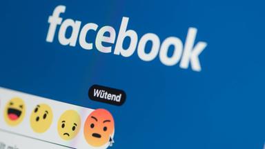 Nahaufnahme eines Smartphones mit der geöffneten Facebook-Webseite.