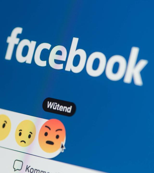 Nahaufnahme eines Smartphones mit der geöffneten Facebook-Webseite.