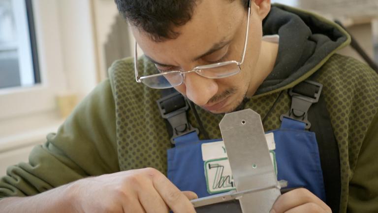 Junger Mann bearbeutet Metallstück