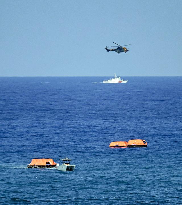 Ein Hubschrauber und Rettungsflöße helfen bei den Such- und Rettungsmaßnahmen nach dem Kentern einer Fähre vor Zyperns Küste.