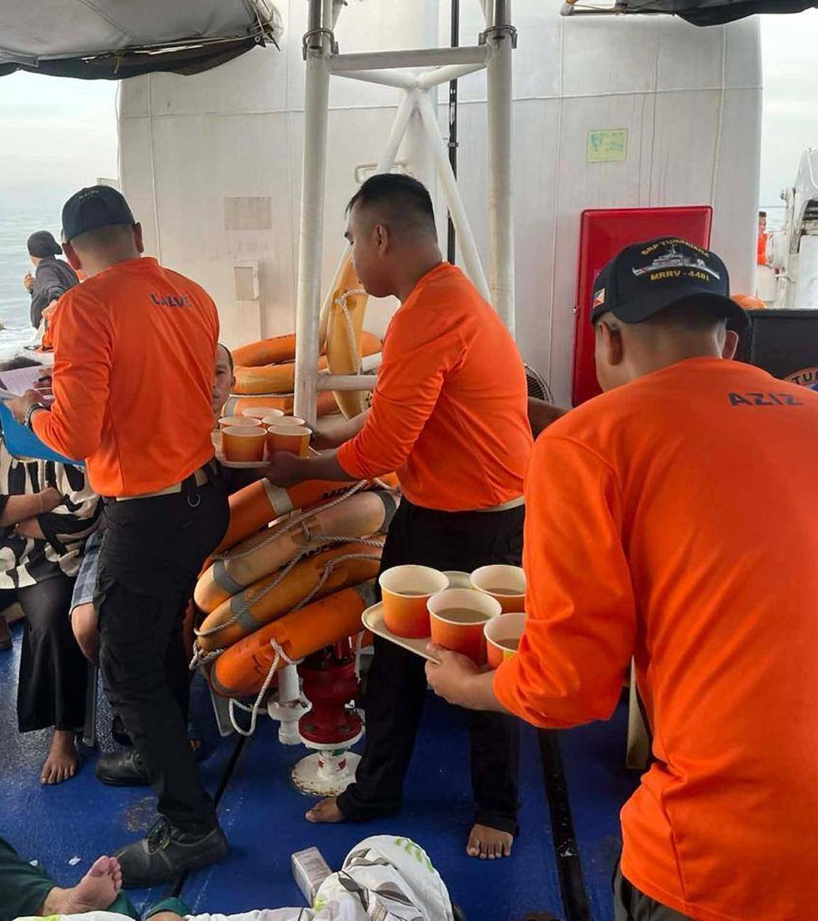 Mitarbeiter der philippinischen Küstenwache kümmern sich auf einem Boot um Menschen, die sich an Bord der gesunkenen M/V Trisha Kerstin 3 befanden