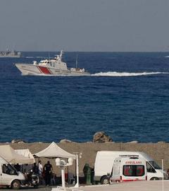 Schiffe fahren in der Nähe des Hafens von Kyrenia vorbei, an Land steht ein Krankenwagen.