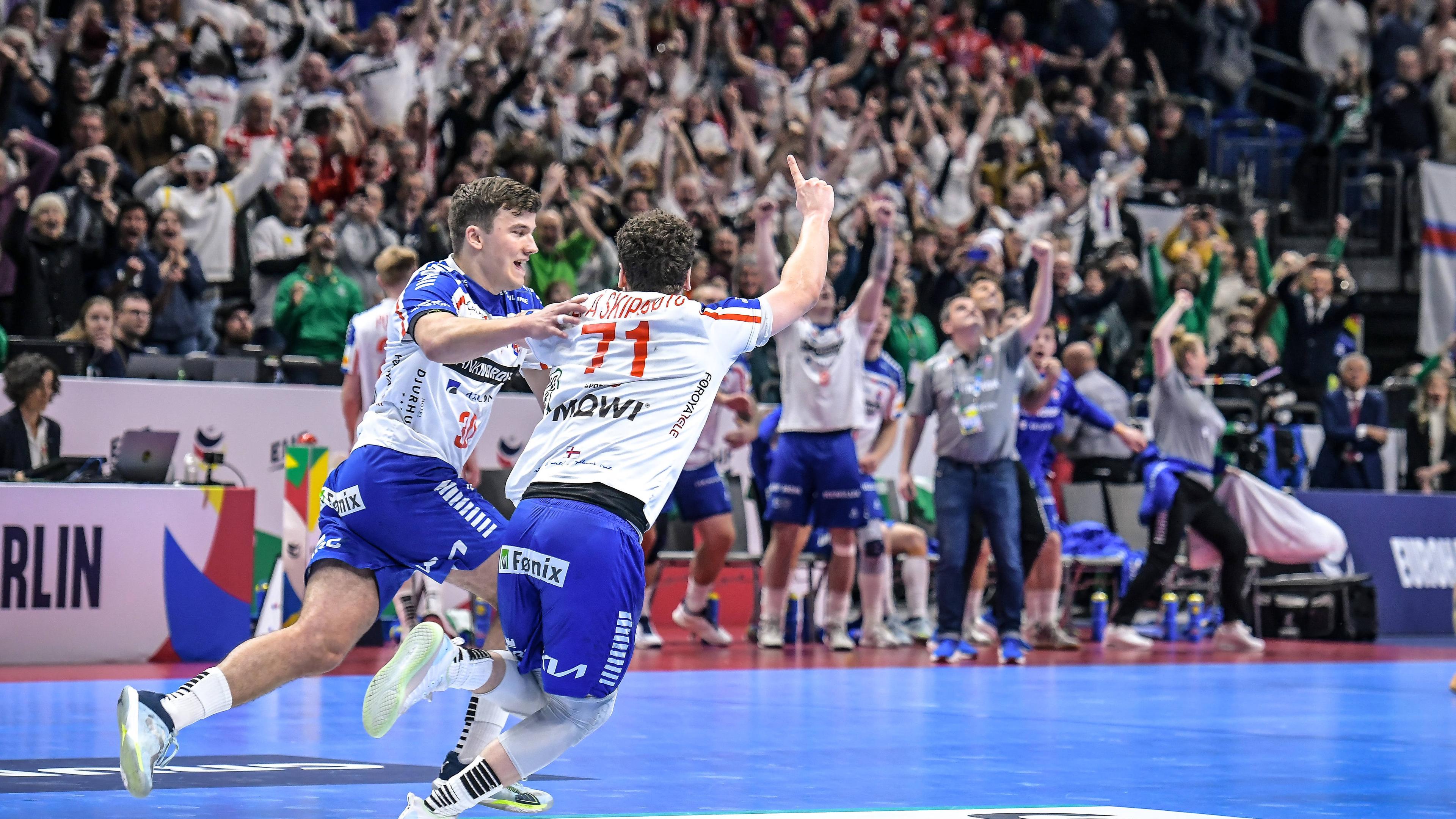 Handball-EM 2024, Norwegen - Färöer Inseln am 13.01.2024: Trondur Mikkelsen (links) und Elias Ellefsen a Skipagotu, der den Treffer zum Unentschieden erzielte, jubeln kurz vor Abpfiff in Richtung der Färöer-Fans.