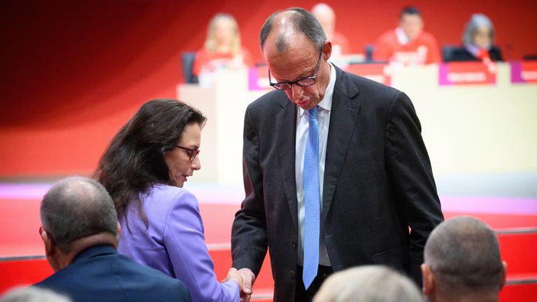 Yasmin Fahimi, Vorsitzende des Deutschen Gewerkschaftsbundes, gibt Bundeskanzler Friedrich Merz (CDU) die Hand.