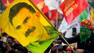 Ein Jugendlicher hält eine Fahne mit dem Bild des inhaftierten Anführers der verbotenen kurdischen Arbeiterpartei PKK, Öcalan.  