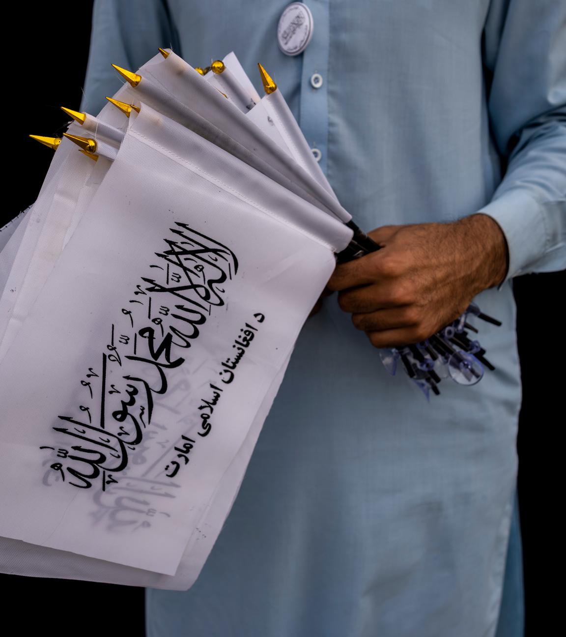 Ein Mann hält Taliban-Fahnen in der Hand (Archivbild) 