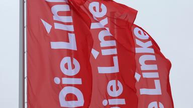 Bayern, Augsburg: Fahnen der Partei Die Linke wehen im Wind.