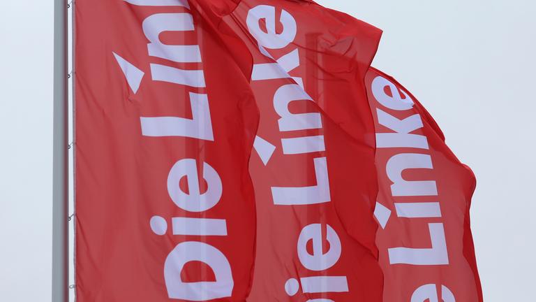 Bayern, Augsburg: Fahnen der Partei Die Linke wehen im Wind.