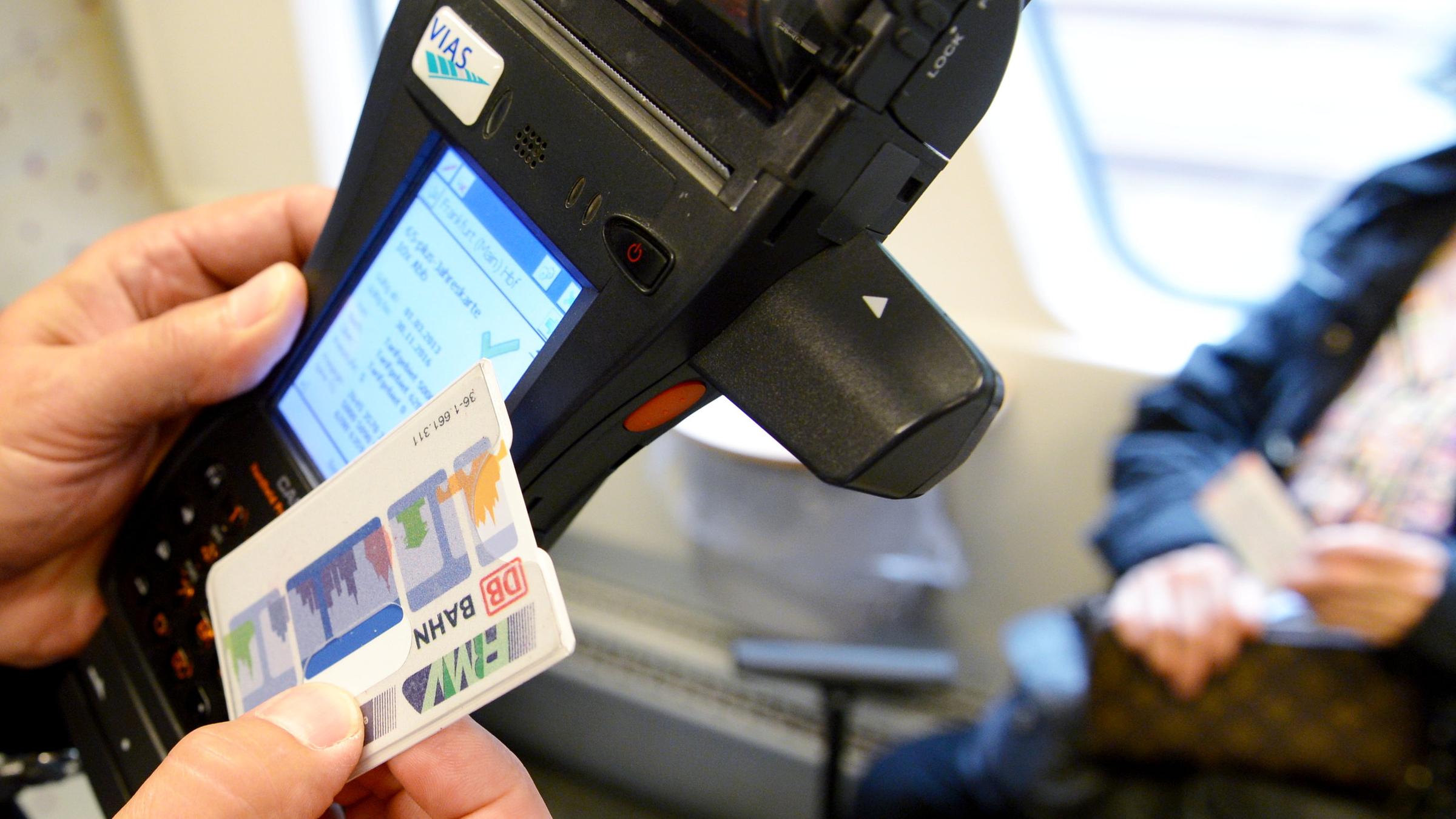 Symbolbild: mit einem mobilen terminal ueberprueft am 04.09.2014 ein fahrkarten-kontrolleur in der odenwaldbahn auf der fahrt von frankfurt am main nach erbach (hessen) die netzkarte eines fahrgastes.