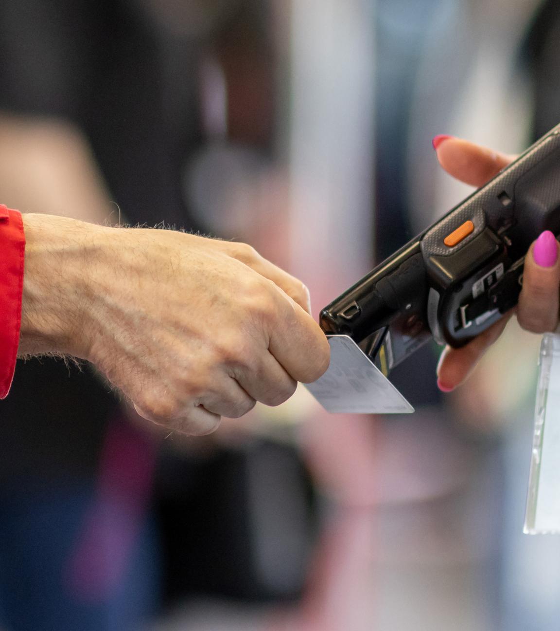Eine Fahrkartenkontrolleurin (r) kontrolliert mit einem elektronischen Lesegerät in der Nürnberger U-Bahn den Fahrschein eines Fahrgastes