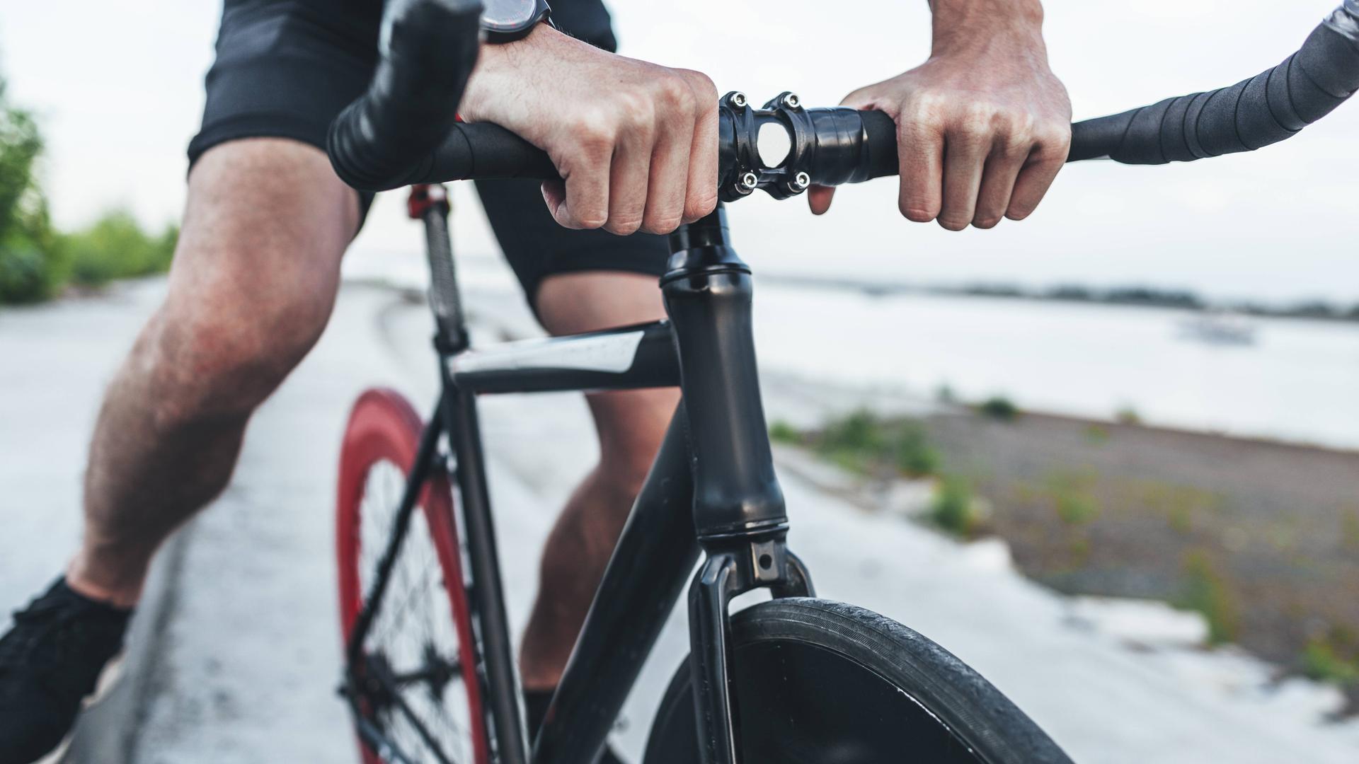 Hände eines Mannes auf einem Fahrradlenker