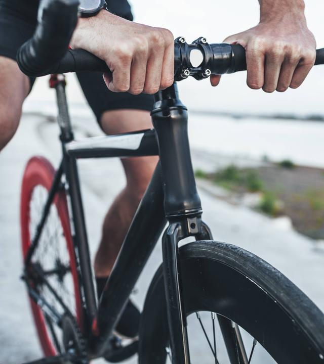 Hände eines Mannes auf einem Fahrradlenker