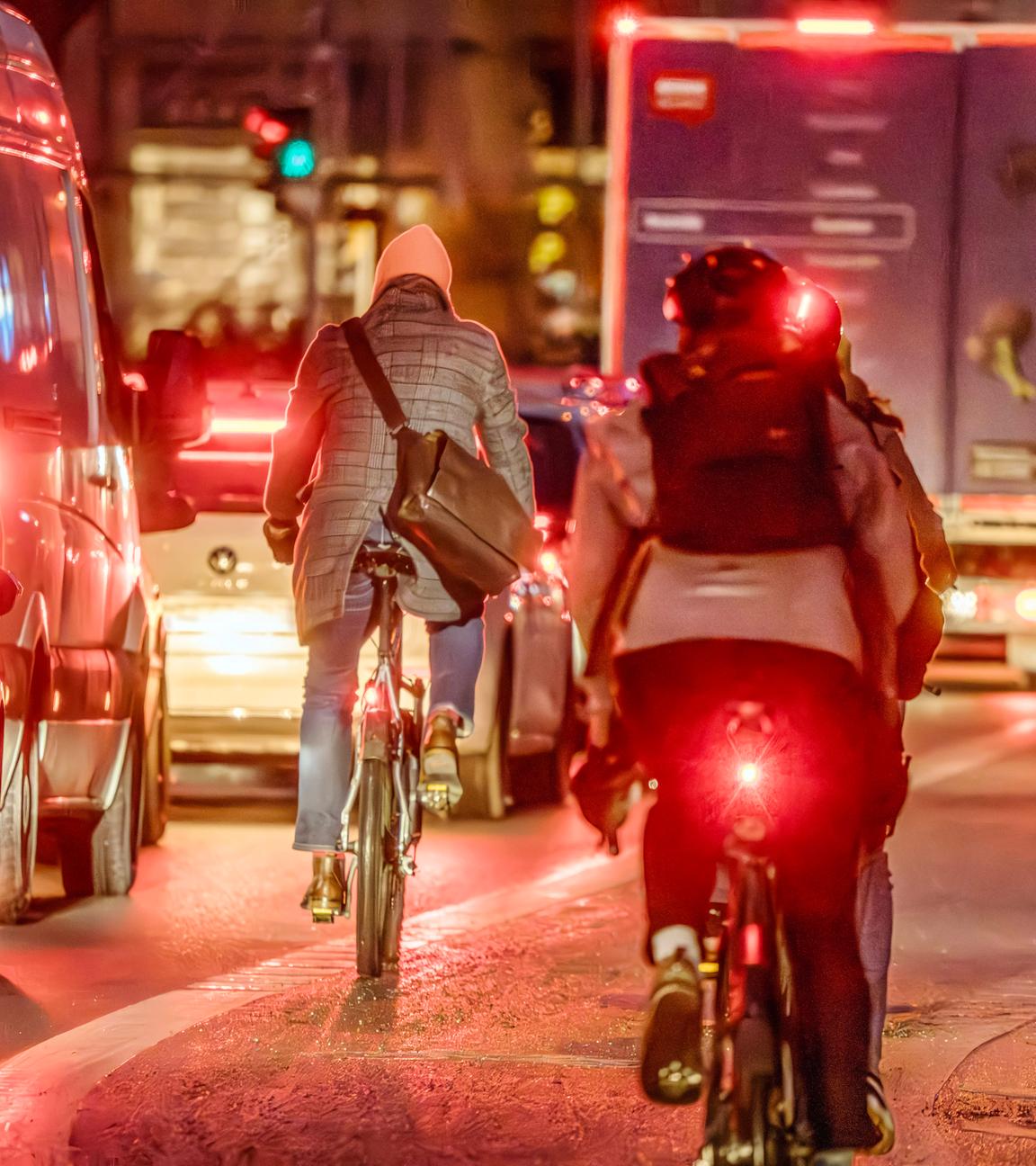Rücklichter von Fahrradfahrern im Straßenverkehr bei Dunkelheit