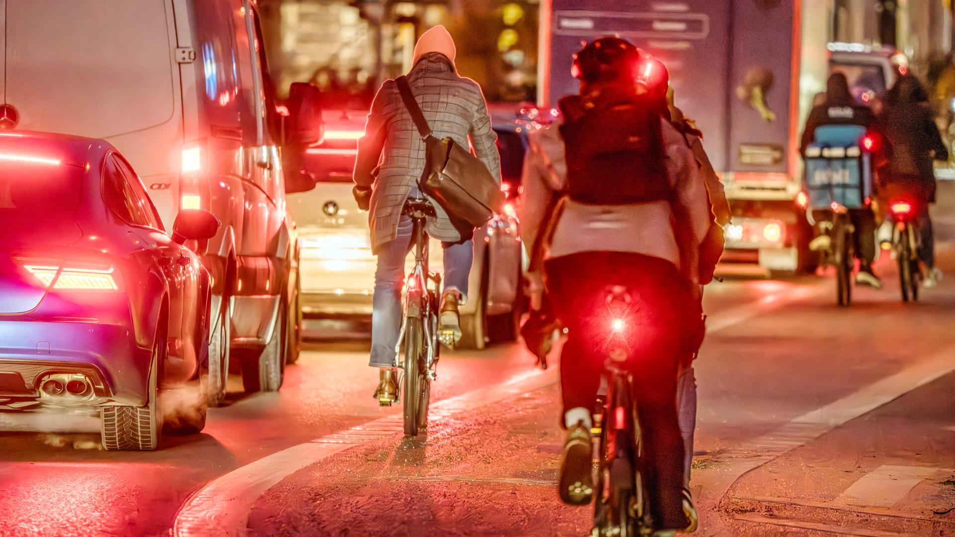 Rücklichter von Fahrradfahrern im Straßenverkehr bei Dunkelheit