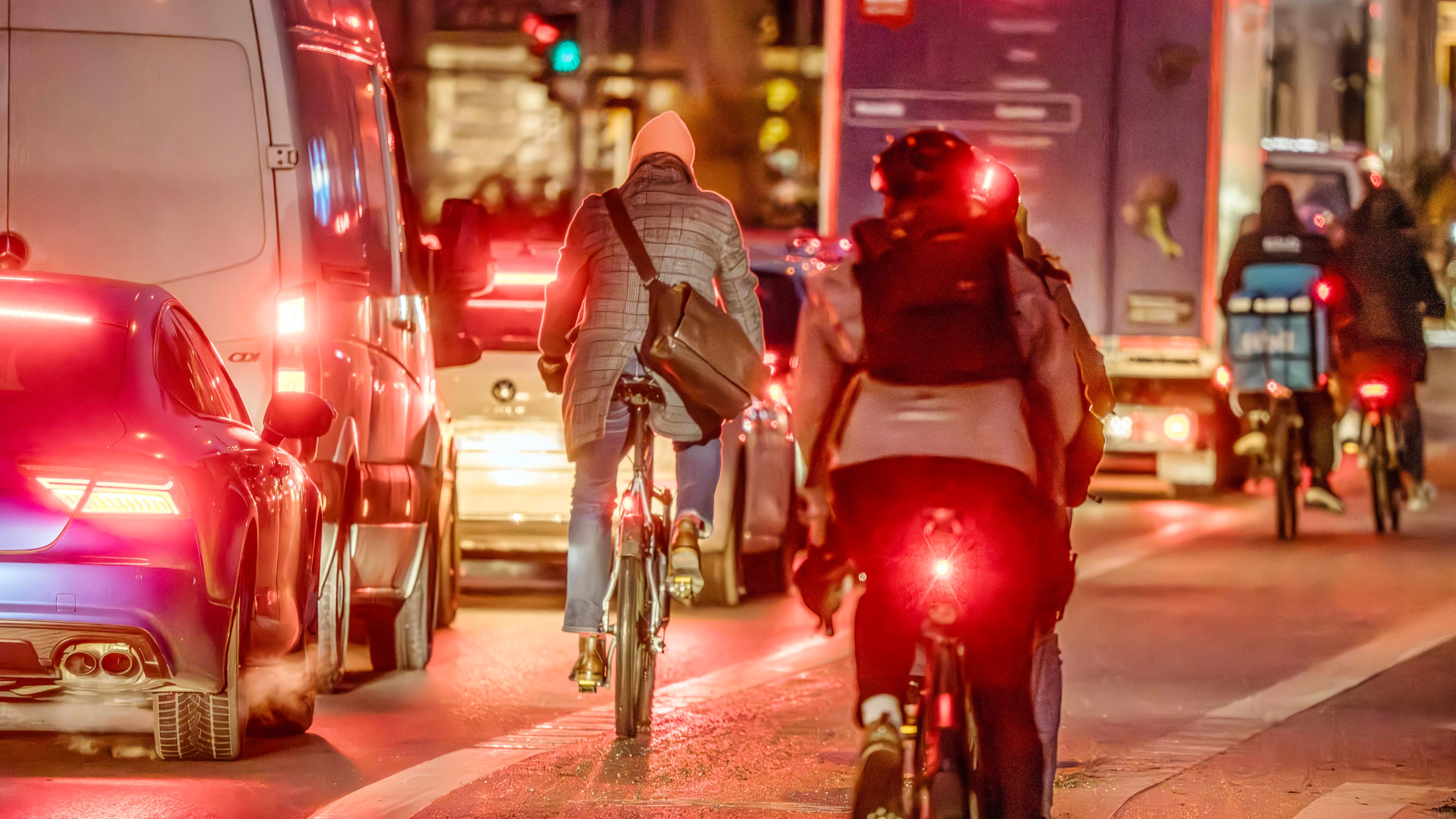 Rücklichter von Fahrradfahrern im Straßenverkehr bei Dunkelheit