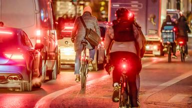 Rücklichter von Fahrradfahrern im Straßenverkehr bei Dunkelheit
