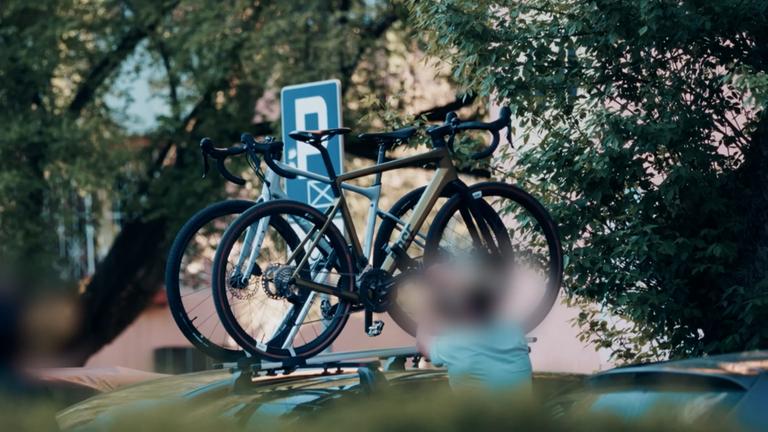 Zwei Fahrräder befinden sich auf dem Gepäckträger eines Autodaches. 