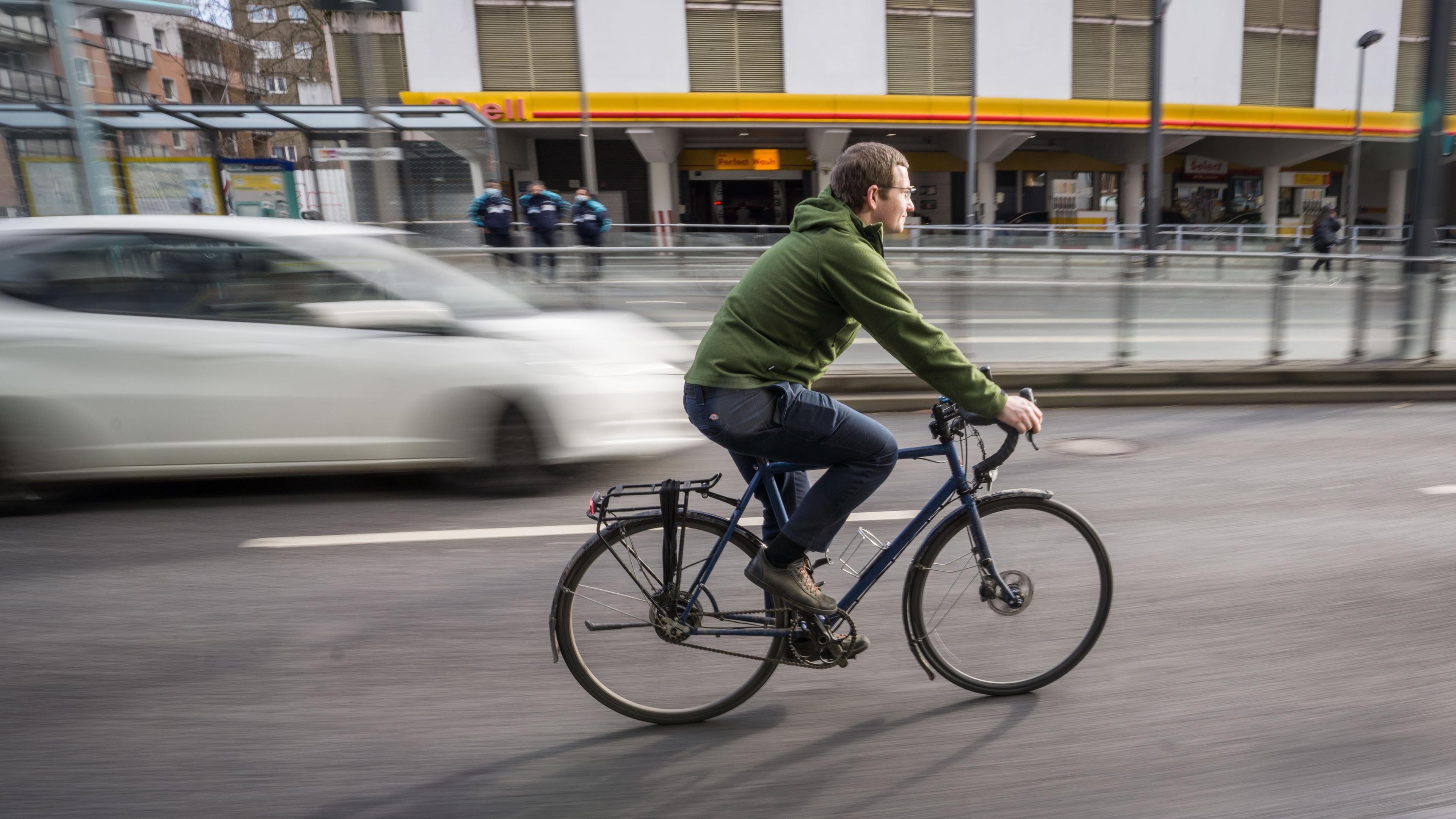 Fahrradfahrer auf Fahrradweg neben Autos,aufgenommen am 02.02.2022 in frankfurt am Main