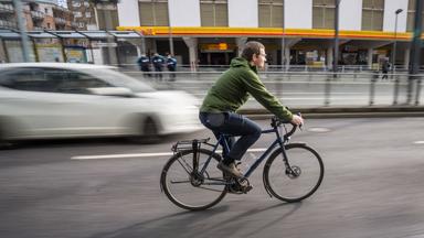 Fahrradfahrer auf Fahrradweg neben Autos,aufgenommen am 02.02.2022 in frankfurt am Main