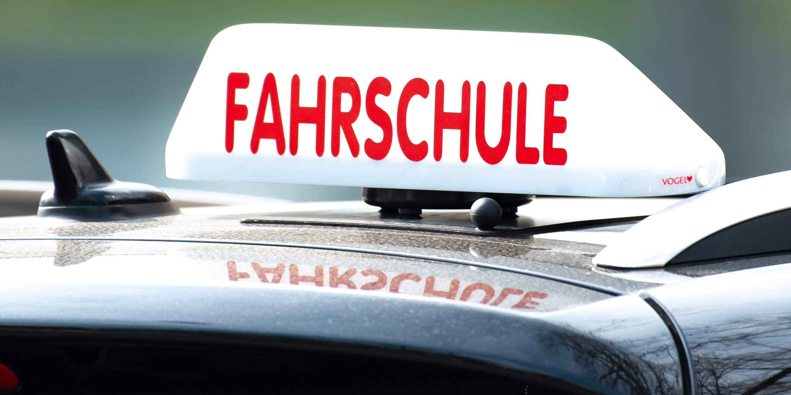 Ein "Fahrschule"-Schild auf einem Autodach