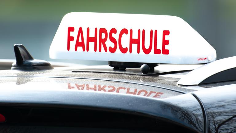 Ein "Fahrschule"-Schild auf einem Autodach