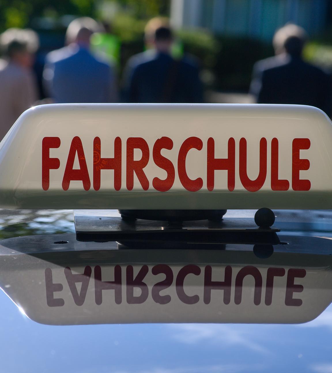 «Fahrschule» ist auf einem Schild auf dem Dach eines Autos zu lesen