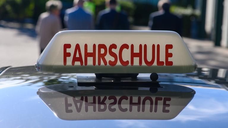 «Fahrschule» ist auf einem Schild auf dem Dach eines Autos zu lesen