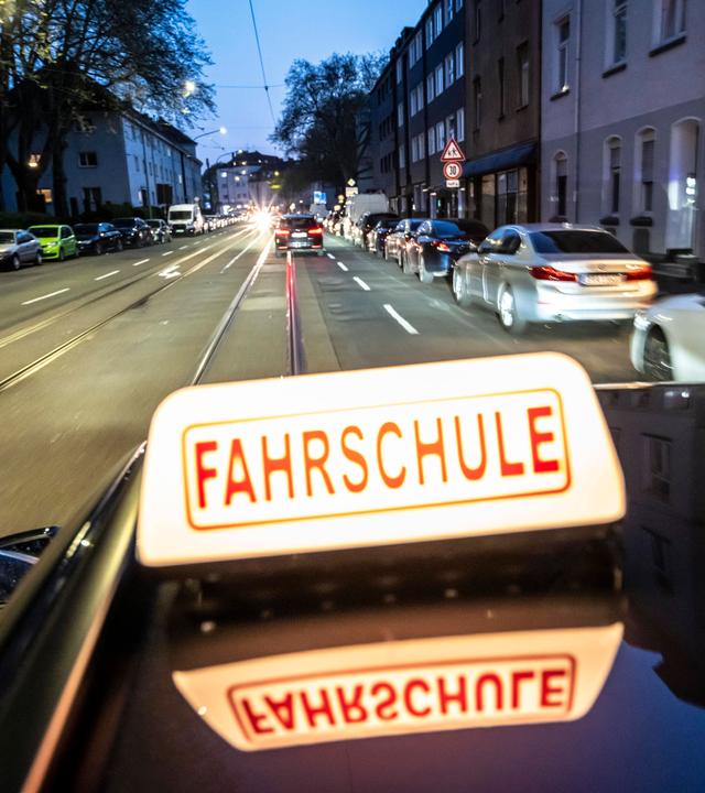 Abendliche Fahrt in einer Innenstadt mit einem Fahrschulauto.