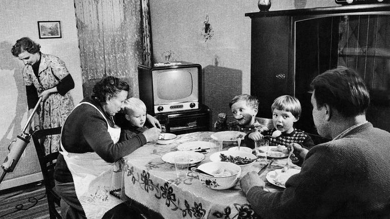 Familie am Esstisch in den 50er-Jahren