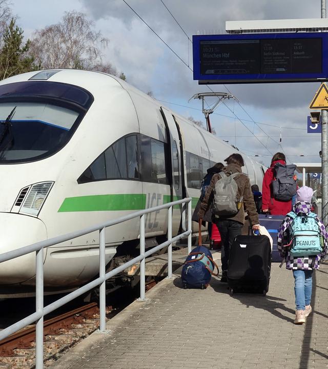 Reisende und ICE T im Bahnhof